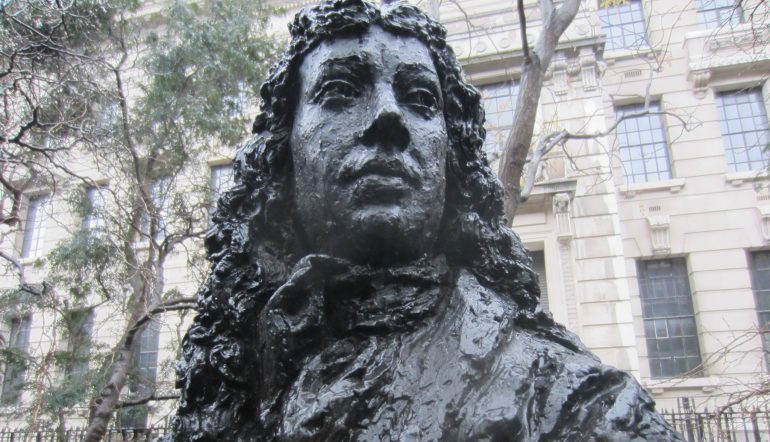 image is a close up on the face of a dark statue bust of Pepys  