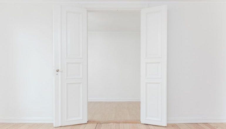 open white double-door with while walls and light wood floor
