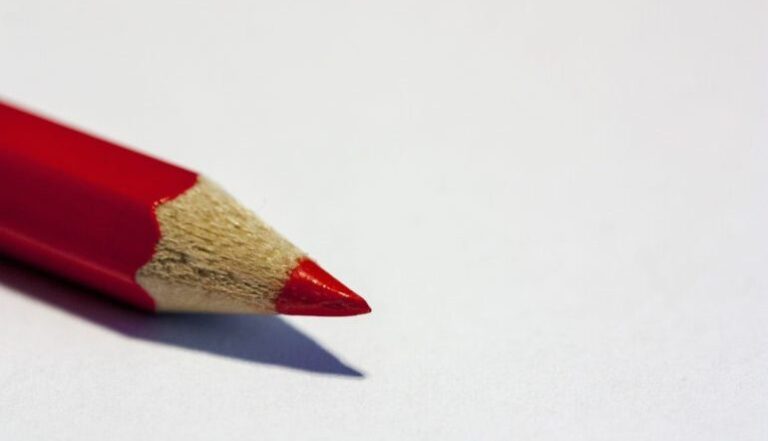 a red colored pencil against a white background