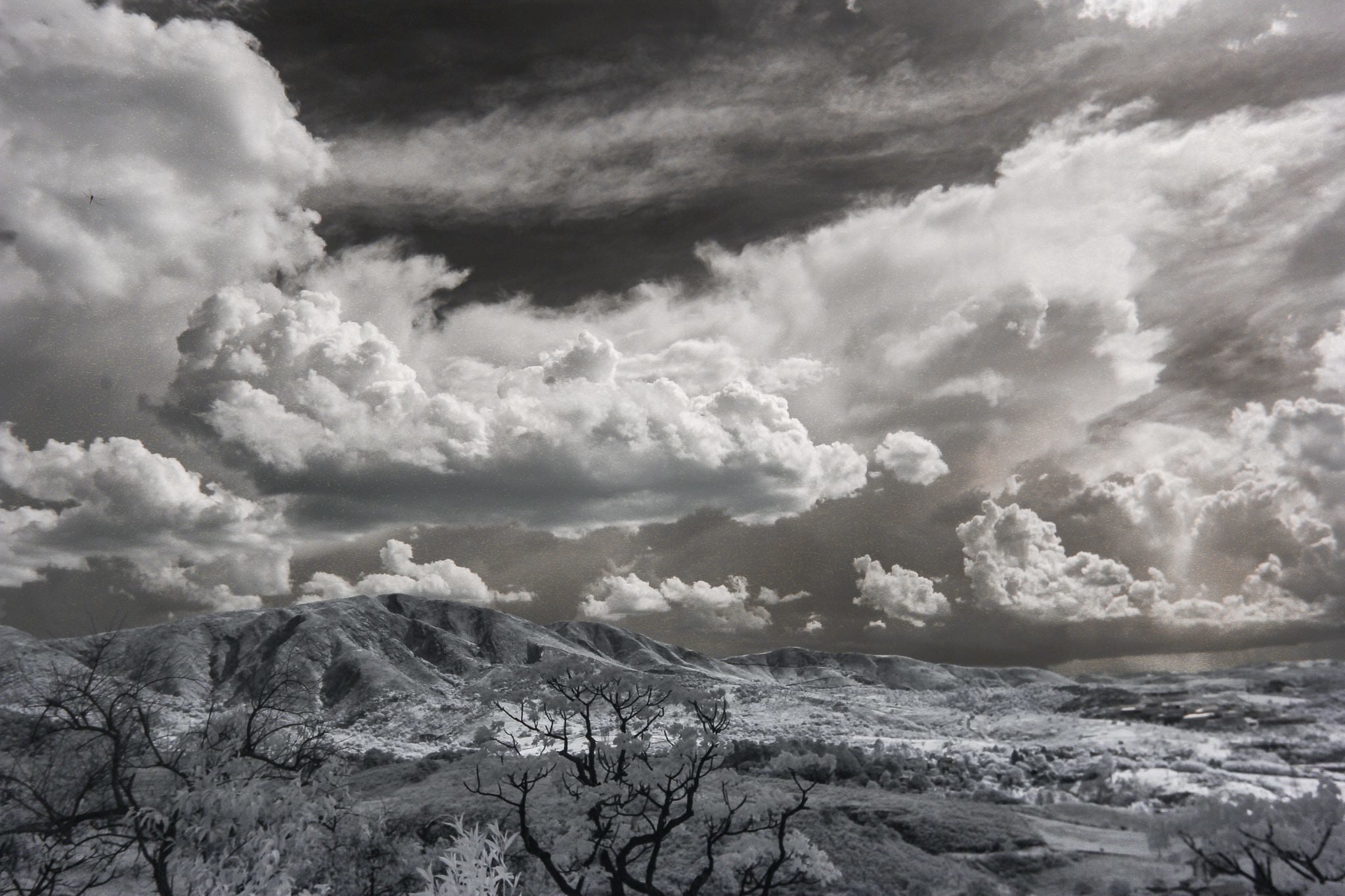 Black and white photograph of storm clouds over a snow-covered mountain range