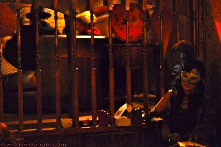 photograph of a woman wearing a mask smoking next to a staircase railing