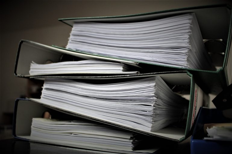 a stack of four binders full of paper in an office setting on top of each other 