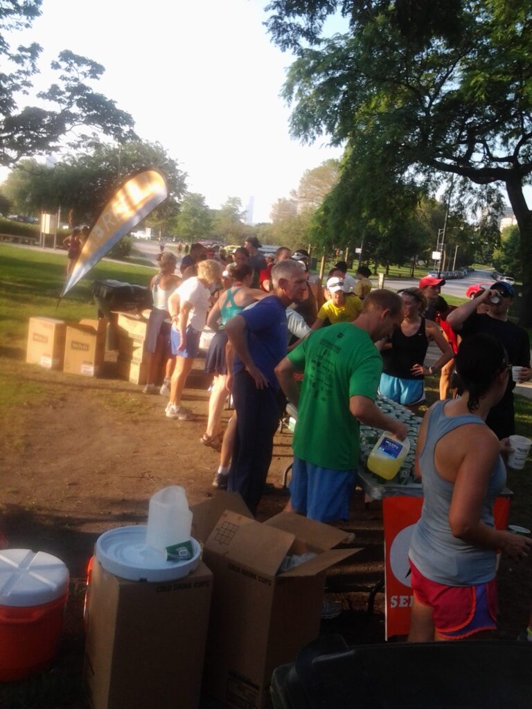 photo of a large crowd of people in a park during the summer