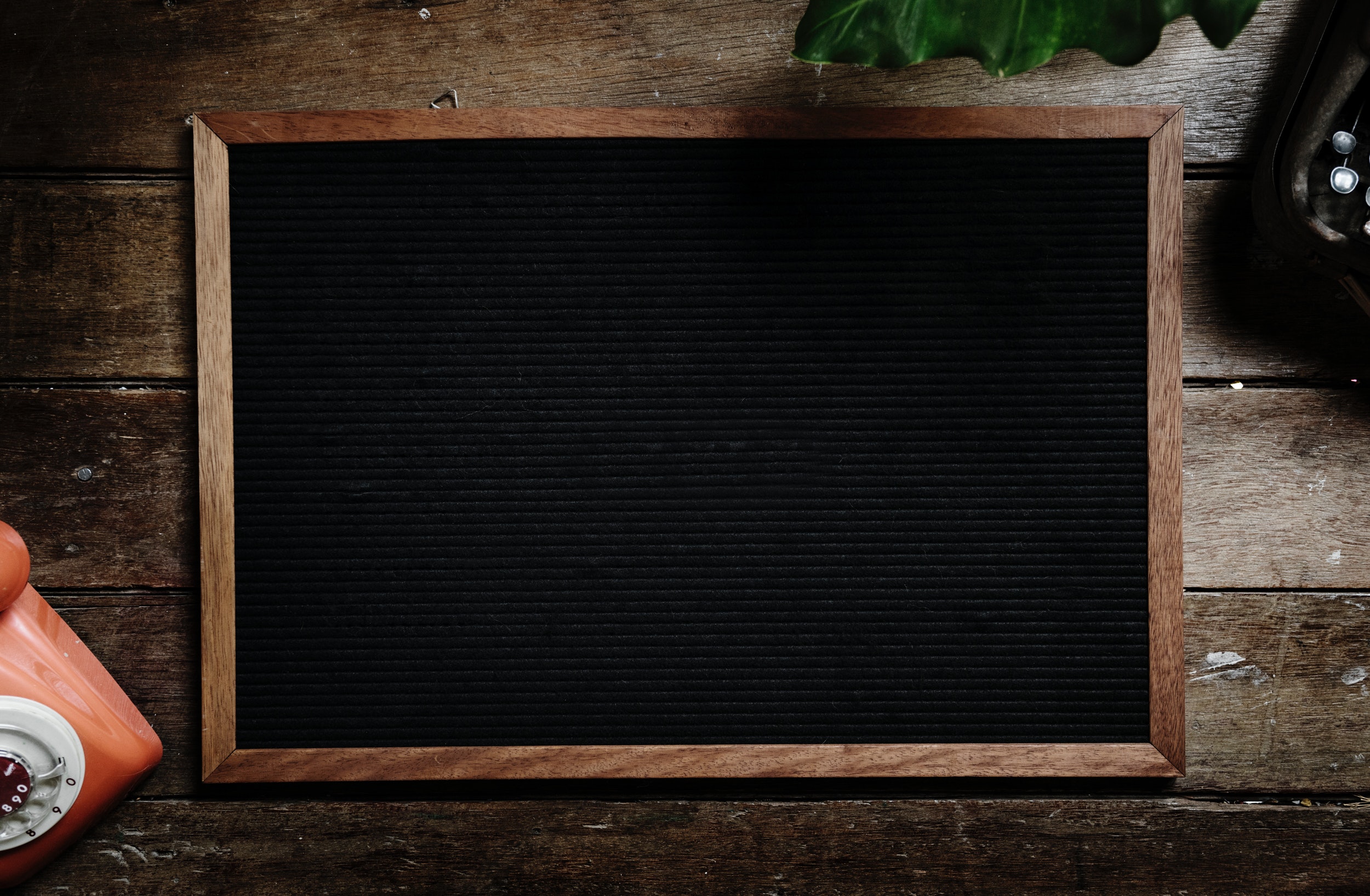 A blank black chalkboard on a wooden table.