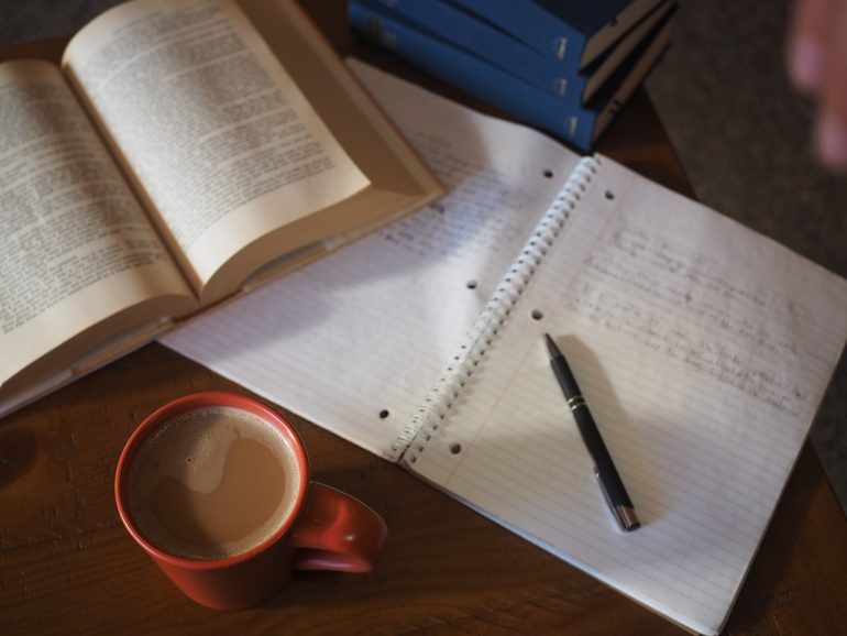 Open book, pen, and cup of coffee 