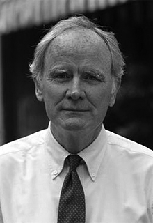 A black and white image of a white man in a suit and tie