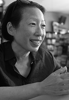 A black and white image of an asian woman smiling