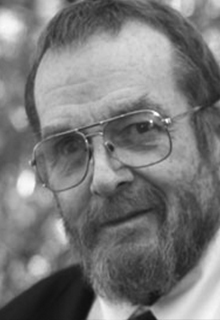 A black and white image of a white man smiling