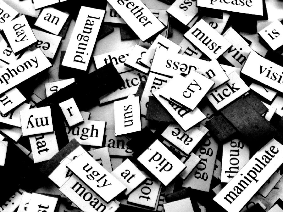Black and white picture of many overlapping word magnets. 