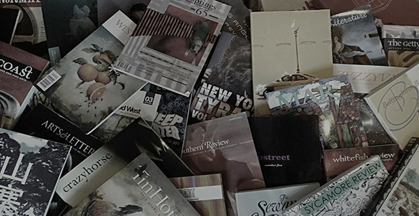 Picture of many literary magazines sprawled on the floor. 