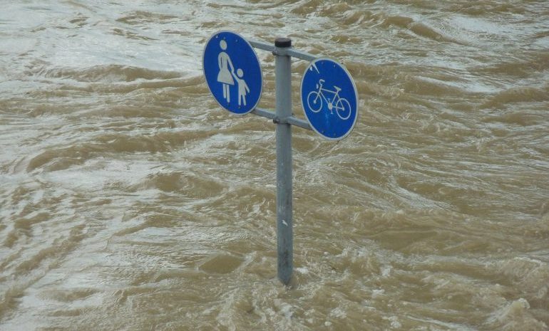 Picture of a street sign in the middle of a flood 
