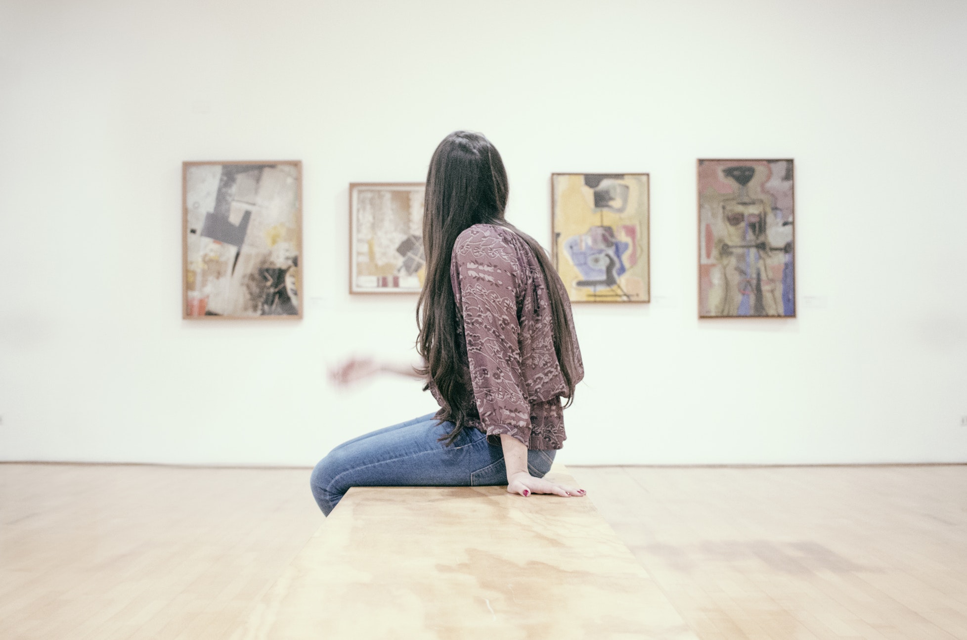 woman sitting on a bench in an art gallery