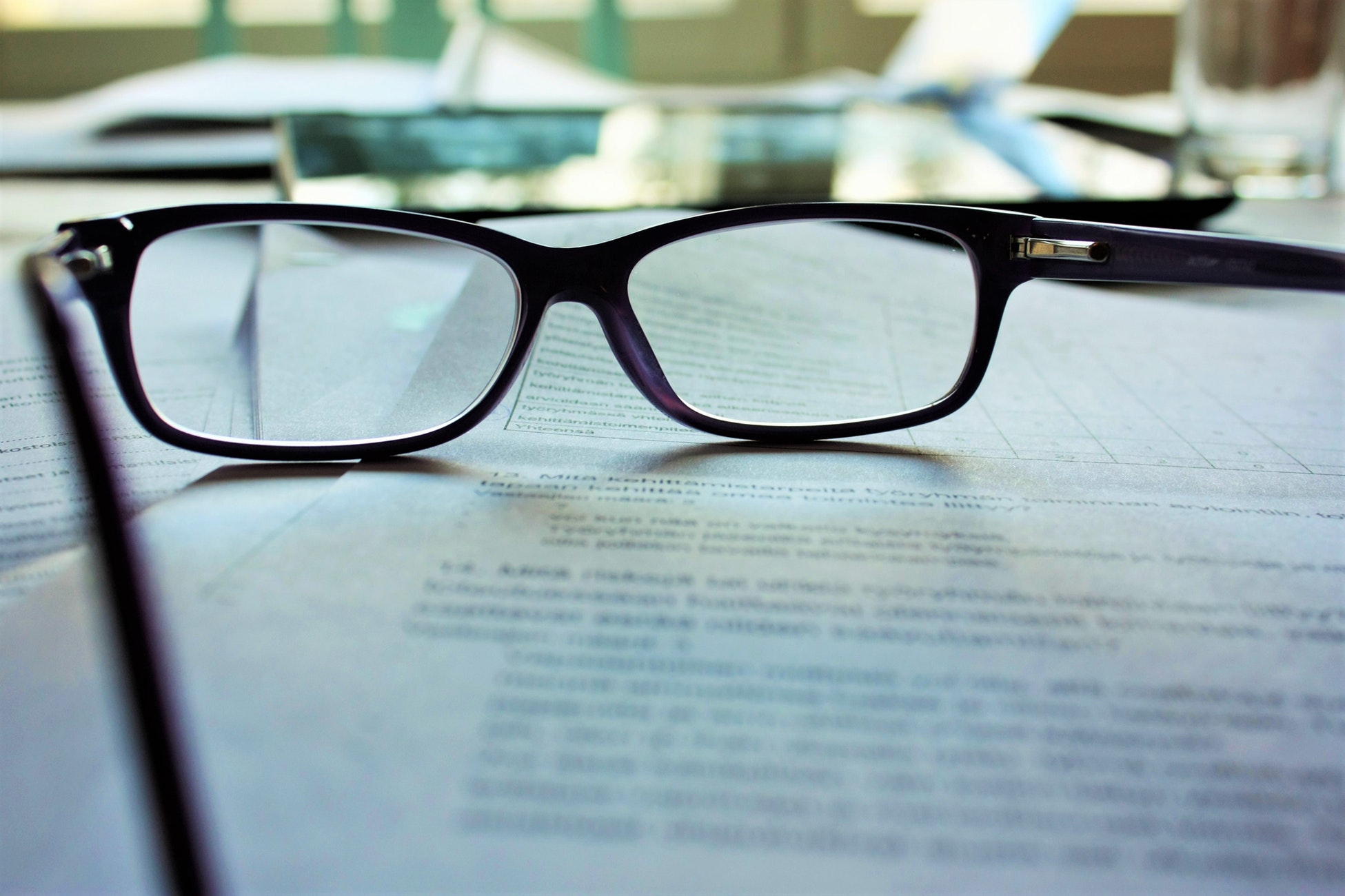 Picture of a pair of black-framed eyeglasses on white printing paper