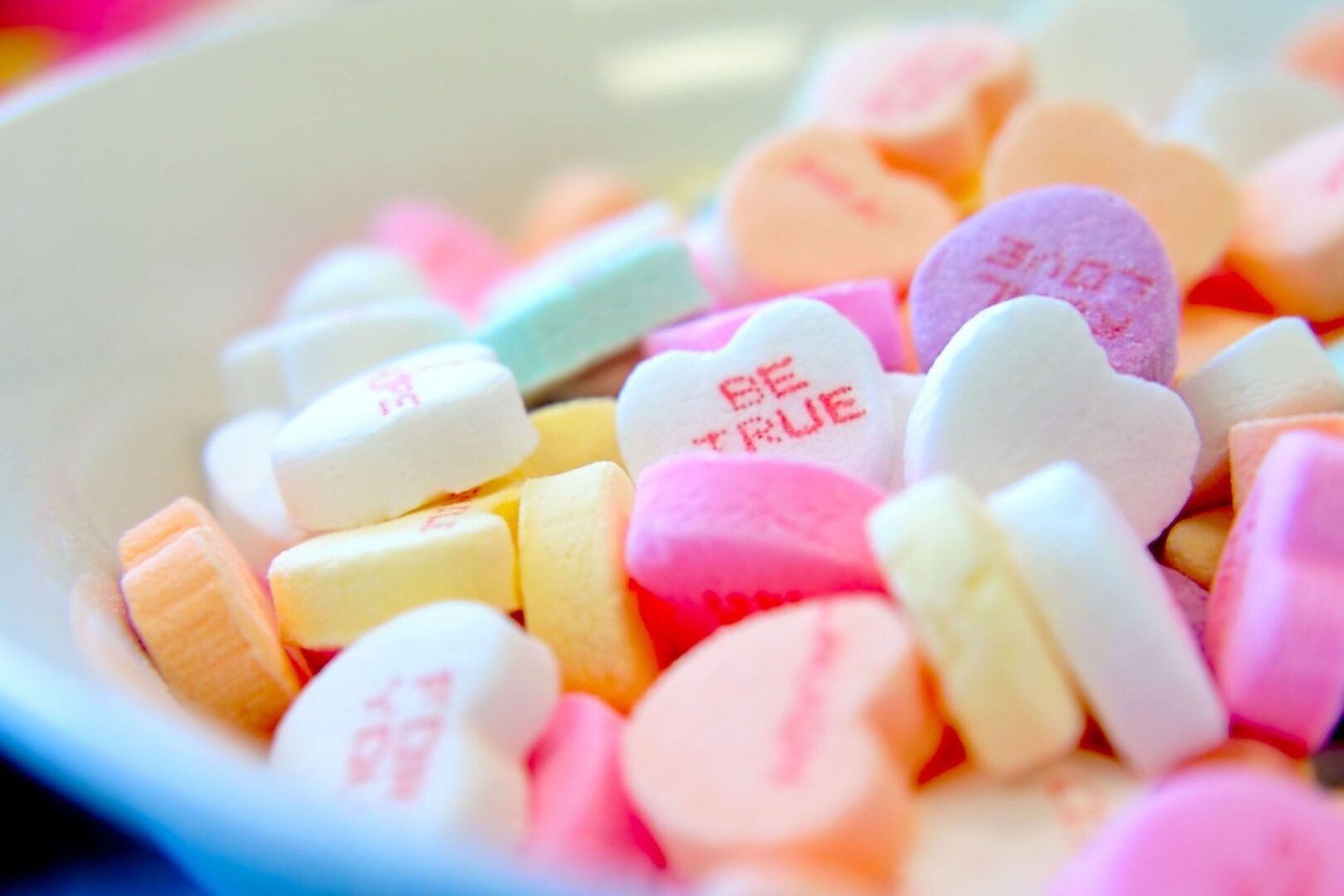 assorted hear-shape candies on a white bowl