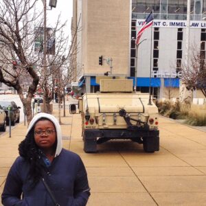 Picture of Jacqui standing with a tank in the background. 