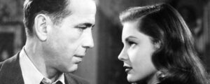 Black and white picture of a man and a woman looking at each other intently. 