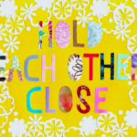 Image that says Hold Each Other Close in bright colors