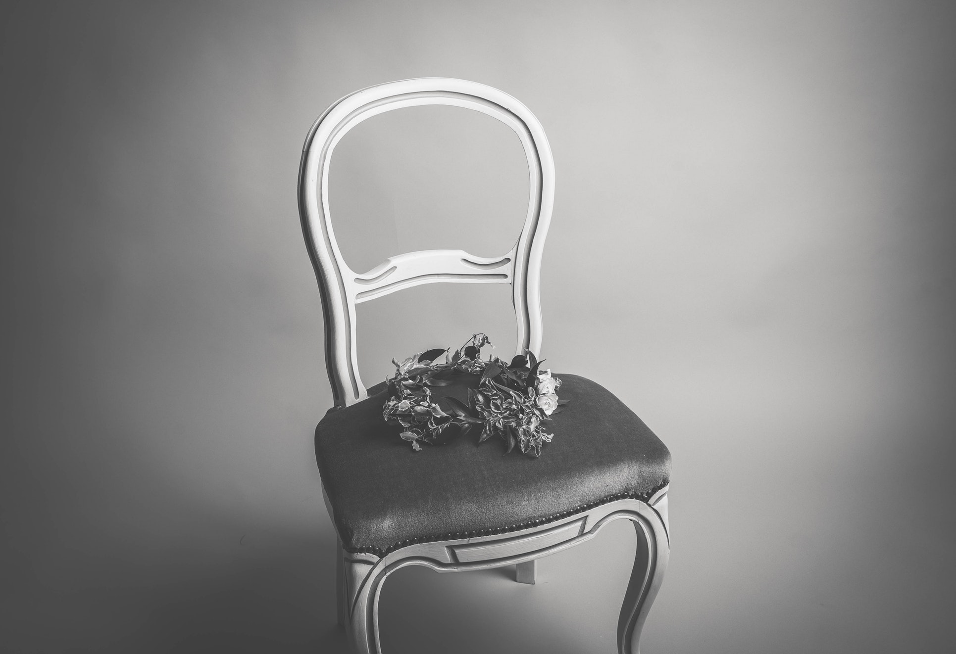 a chair in a dark room with flowers on top of it