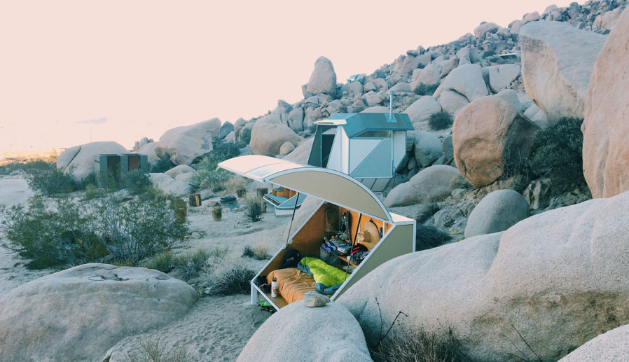 A small camper setup on a rocky hill.