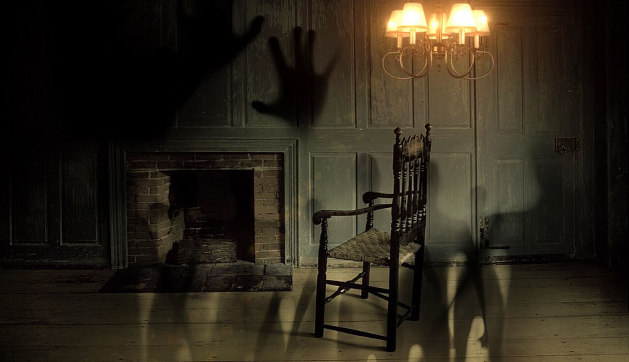 A dimly lit room with a single chair and shadows overlaid onto the image.