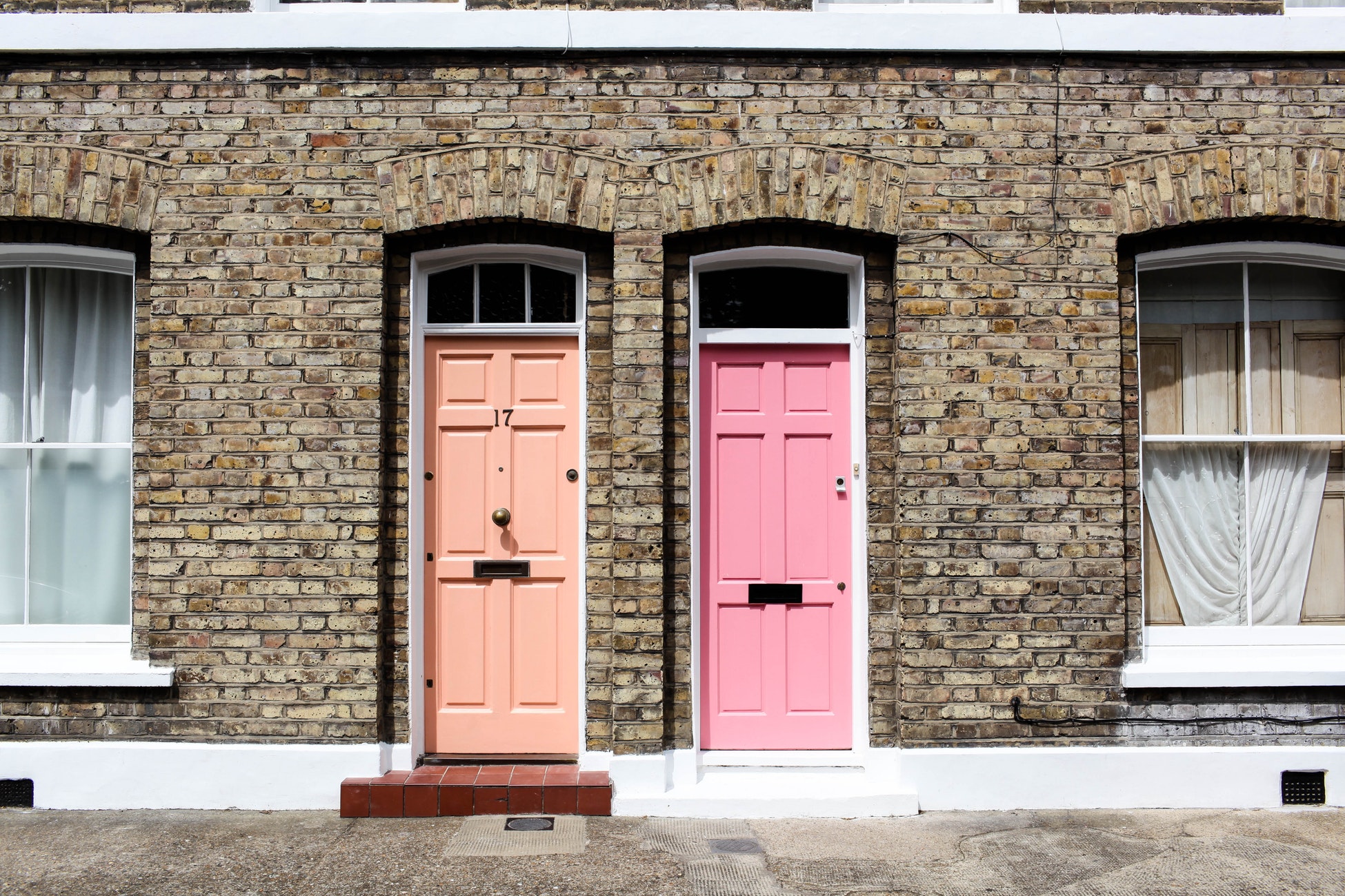 Two doors, orange and pink, in the daylight