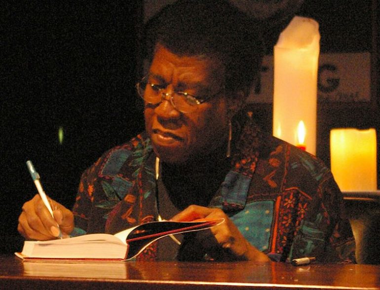 A person signing a book at a desk.