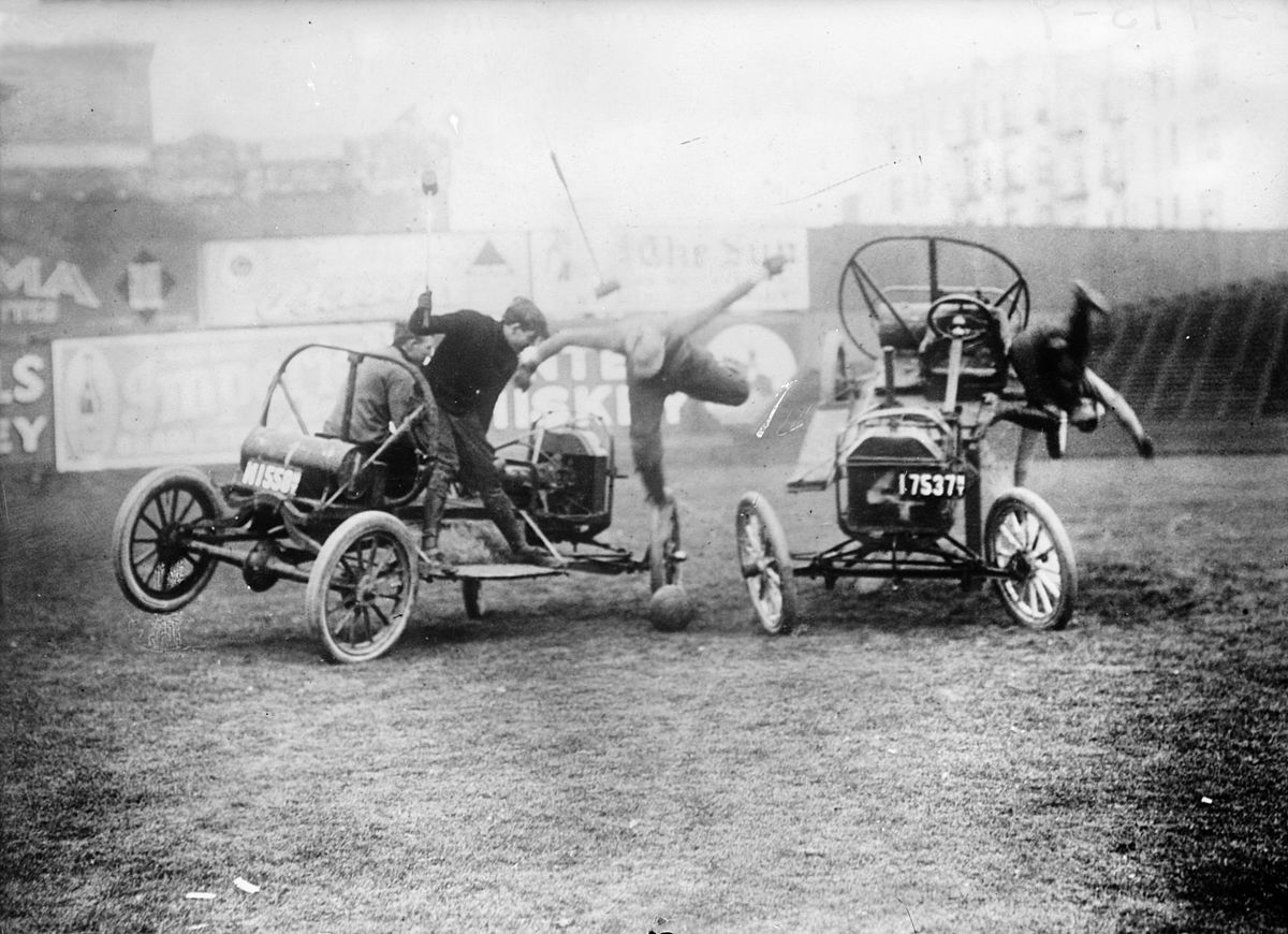 Old photograph of people playing on old car-looking prototypes.