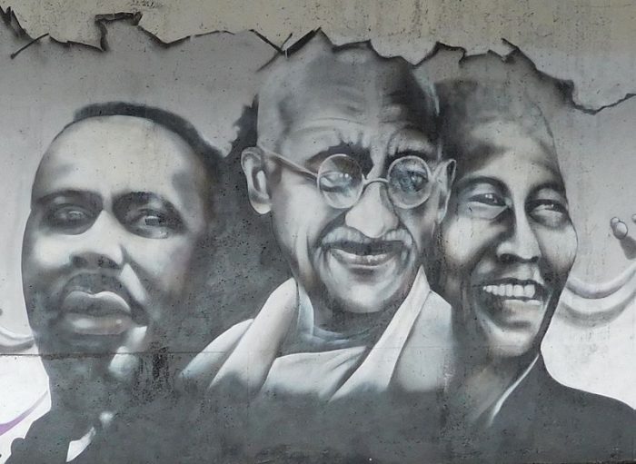 Faces of three men painted on a wall.