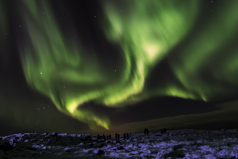 Green Northern Lights over a snowy landscape.
