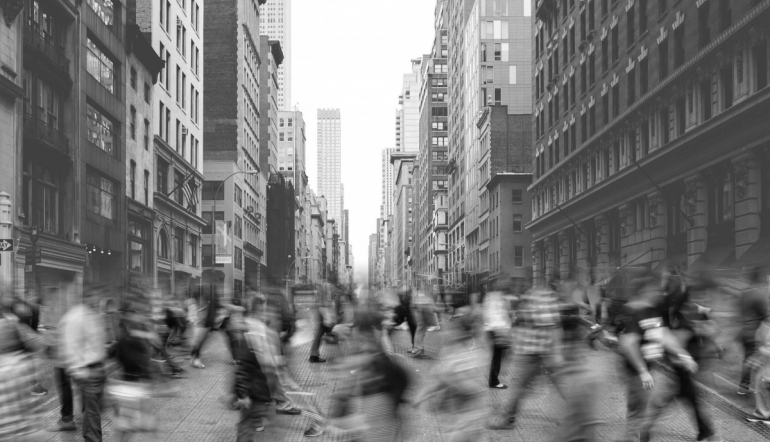 pedestrians blurred from motion walking across a street in New York City