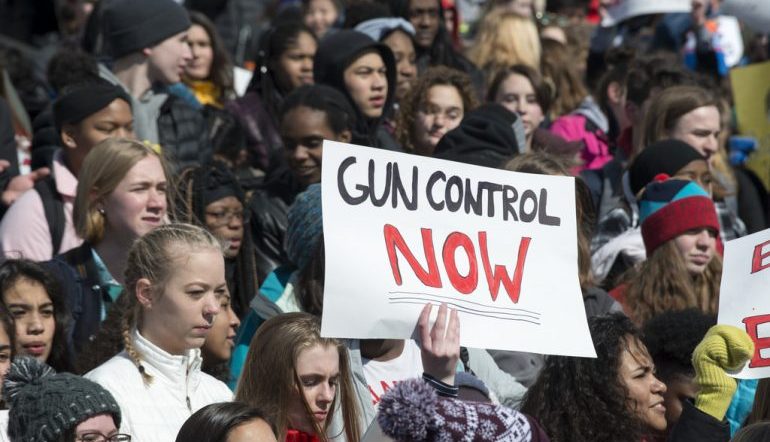 March for Our Lives student protest, a sign reads "gun control now"