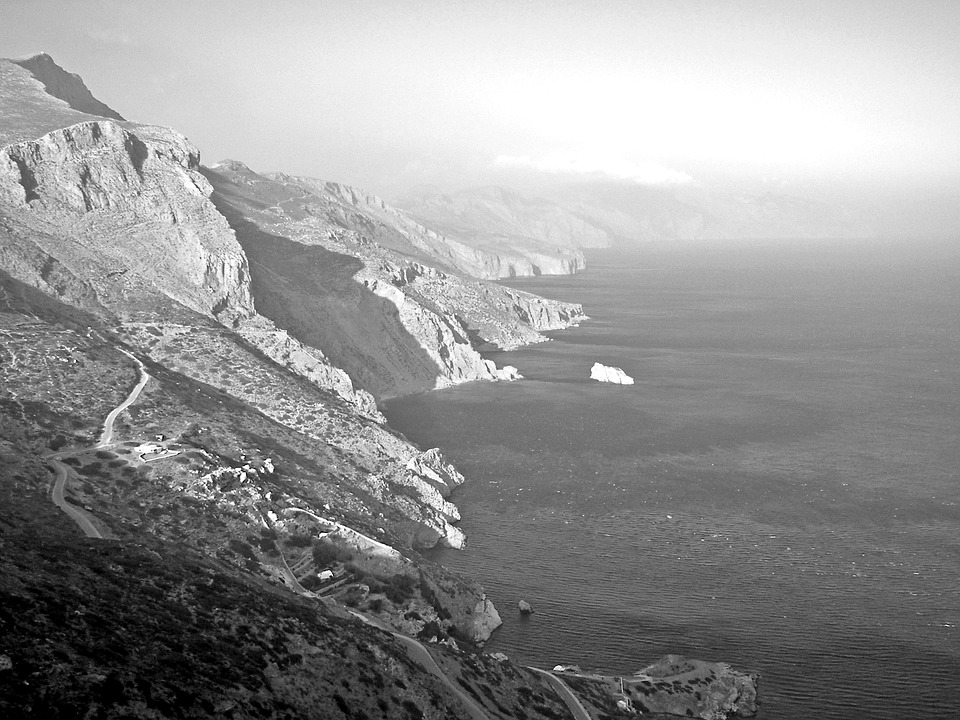 a black and white photograph of cliffs in Greece