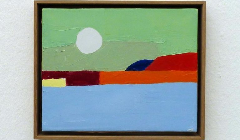 White wall with a framed painting centered. Painting shows a green sky, a white sun, red rocks, and blue water, all very abstract and color-blocked