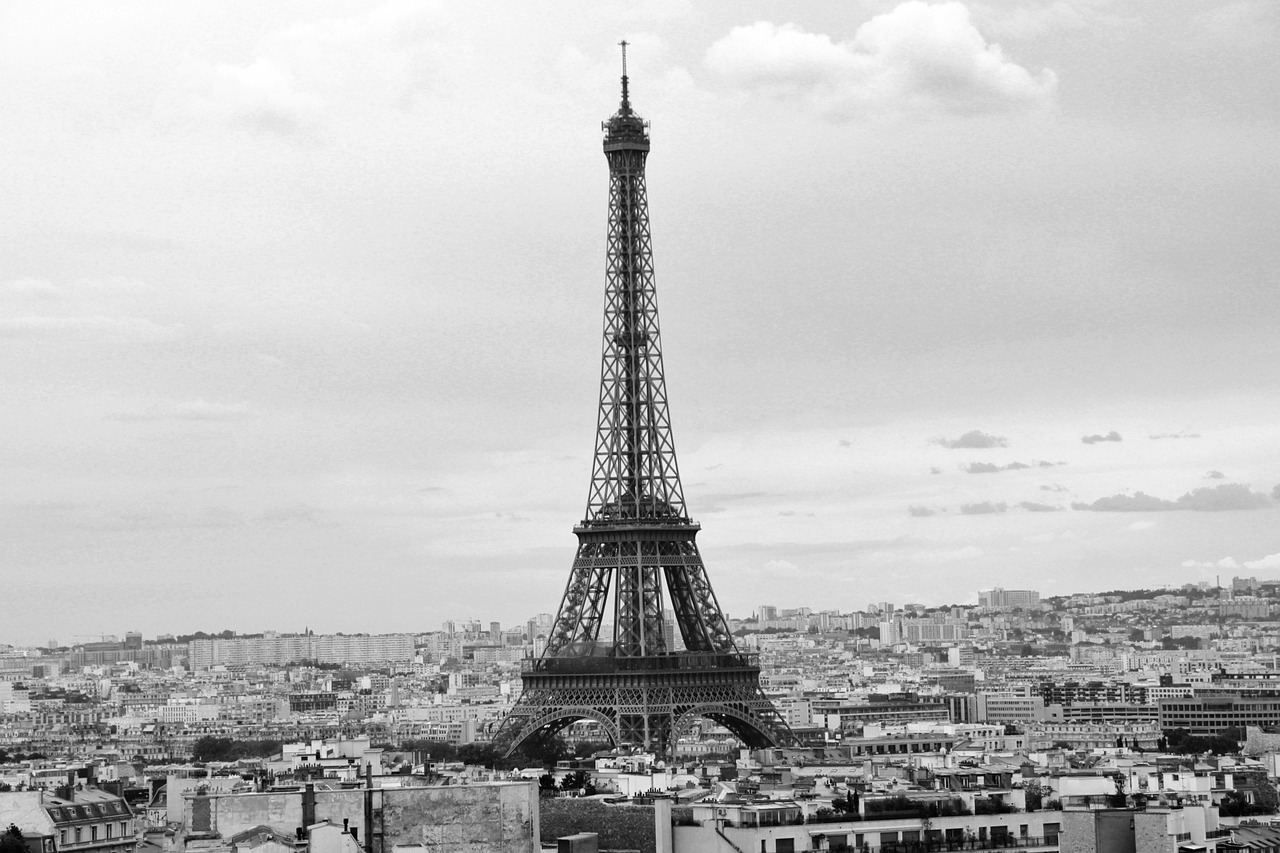 a black and white photograph of the Eiffel Tower standing over Paris