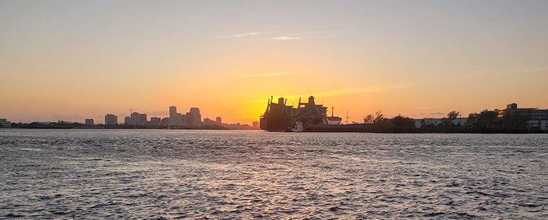 a distant city skyline at sunset taken across the water