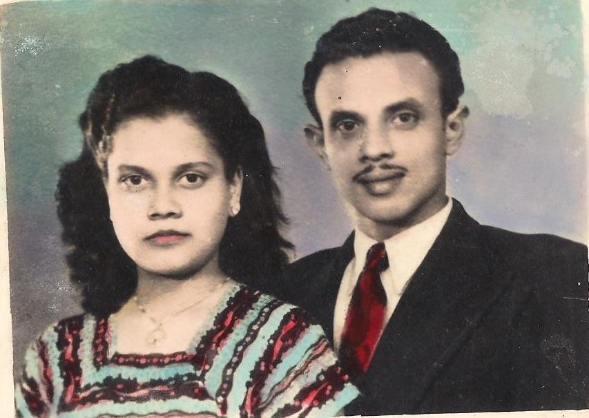 the photo the writer describes in the piece in which the writer's grandmother "stands beside my grandfather. Both of them wear Western clothing, my grandfather a black suit with a red tie and my grandmother a blue dress with red embroidery. Their outfits look painted onto them, the clashing hues seeping into each other like watercolor"