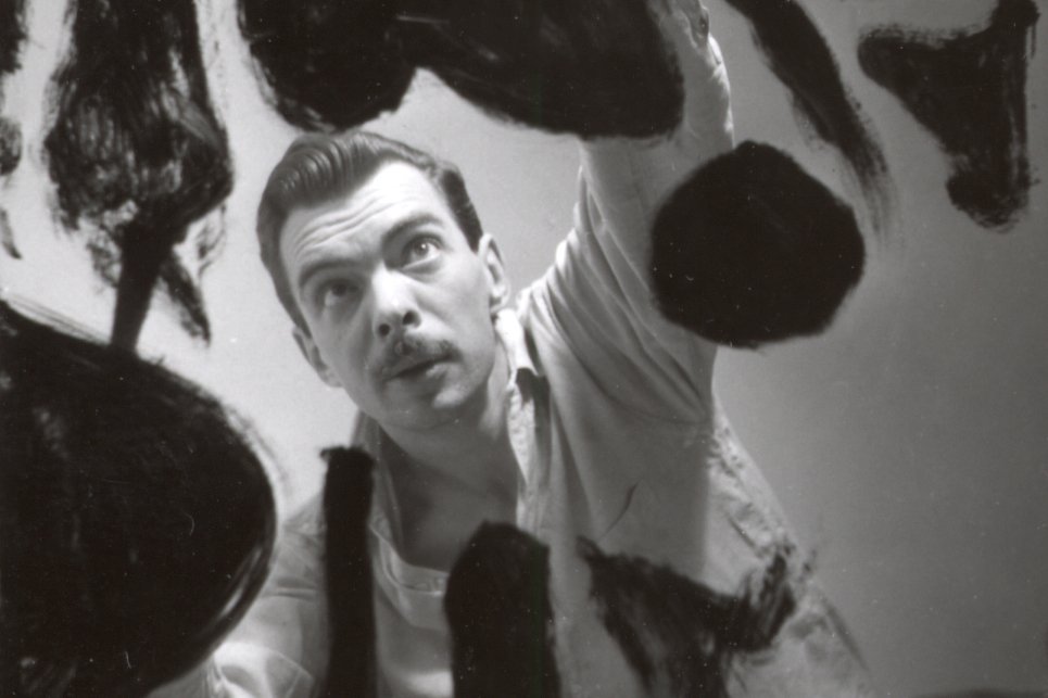 Weldon Kees painting splotches on a canvas, taken from the perspective of the canvas